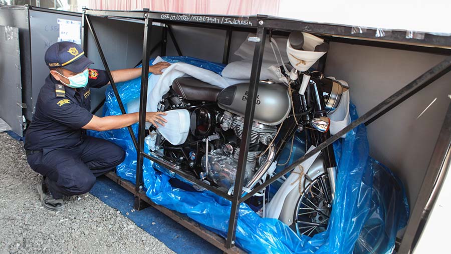 Petugas Bea Cukai mengecek motor Royal Enfield yang dilelang di gudang TPP, Jakarta, Selasa (1/8/2023). (Bloomberg Technoz/Andrean Kristianto)