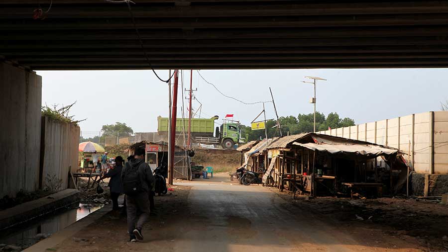 Truk-truk besar lalu-lalang di kawasan ini, meninggalkan debu-debu dari proyek tersebut. (Bloomberg Technoz/ Andrean Kristianto)