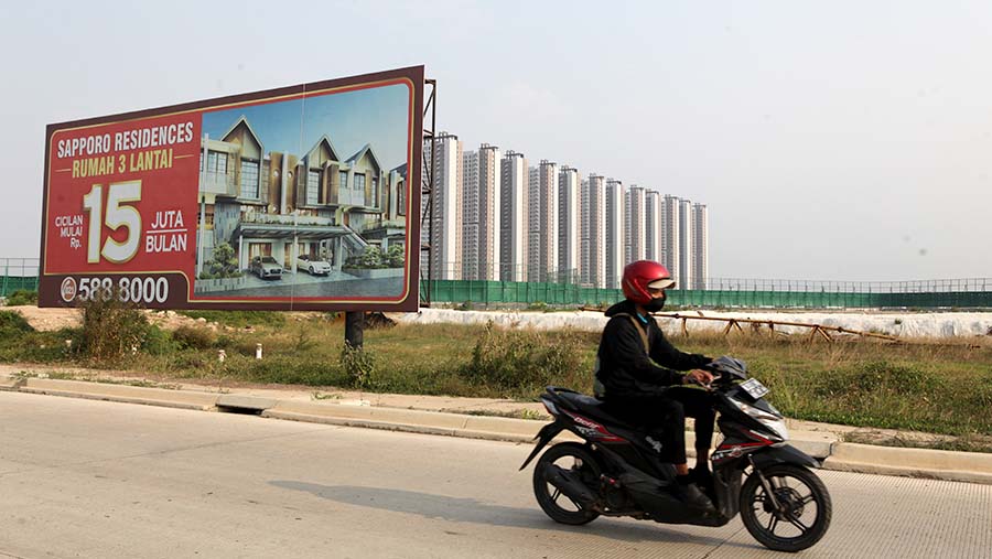 Motor melintas dengan latar apartemen di kawasan PIK 2, Tangerang, Rabu, (2/8/2023). (Bloomberg Technoz/ Andrean Kristianto)
