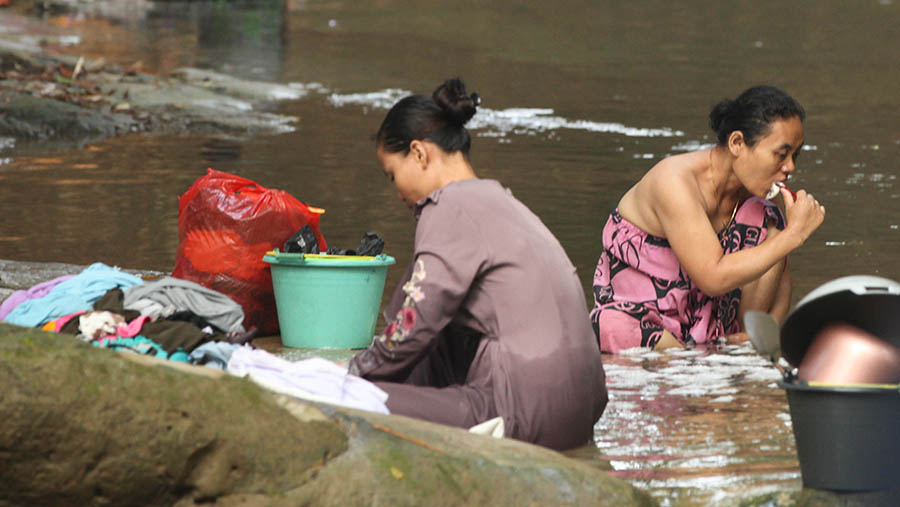 Sebagian warga di Desa Ridogalih, Cibarusah, kini terpaksa mandi dan mencuci pakaian di Kali Cihoe. (Bloomberg Technoz/ Andrean Kristianto)