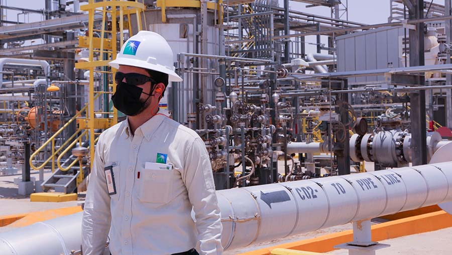 Pekerja berjalan di Pabrik Pemulihan Cairan Gas Alam Hawiyah Saudi Aramco di Hawiyah, Arab Saudi, Senin (28/6/2021). (Maya Siddiqui/Bloomberg)