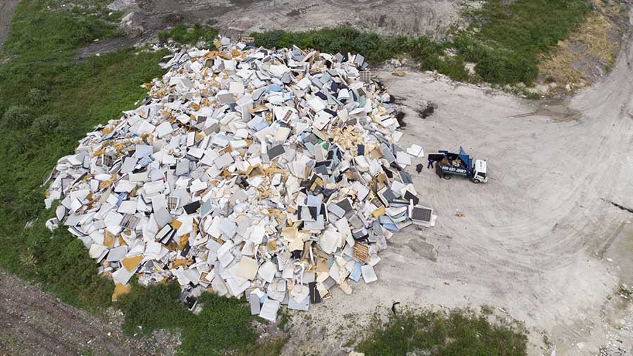 Pekerja memindahkan sampah dari truk di TPA Miami Dade County North Dade di Miami Gardens, Florida, AS, Rabu, (26/7/2023). (Marco Bello/Bloomberg)
