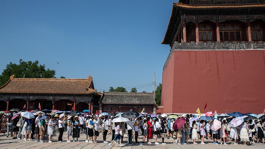 Pengunjung mengantri untuk memasuki Museum Istana di Kota Terlarang di Beijing, China, Minggu  (13/8/2023). (Bloomberg)
