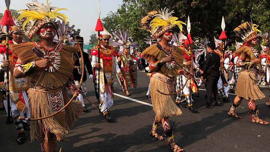 Orang-orang yang mengiringi mengenakan berbagai busana adat dari seluruh Indonesia.. (Bloomberg Technoz/ Andrean Kristianto)