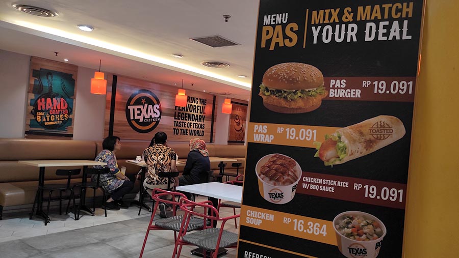 Pengunjung berbincang di restoran cepat saji Texas Chicken di Jakarta, Jumat (18/8/2023). (Bloomberg Technoz/ Andrean Kristianto)