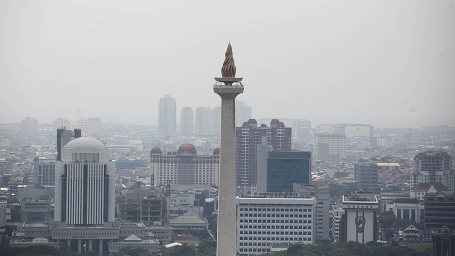 Suasana tugu Monas dengan latar gedung berkabut polusi di Jakarta, Senin (21/8/2023). (Bloomberg Technoz/ Andrean Kristianto)