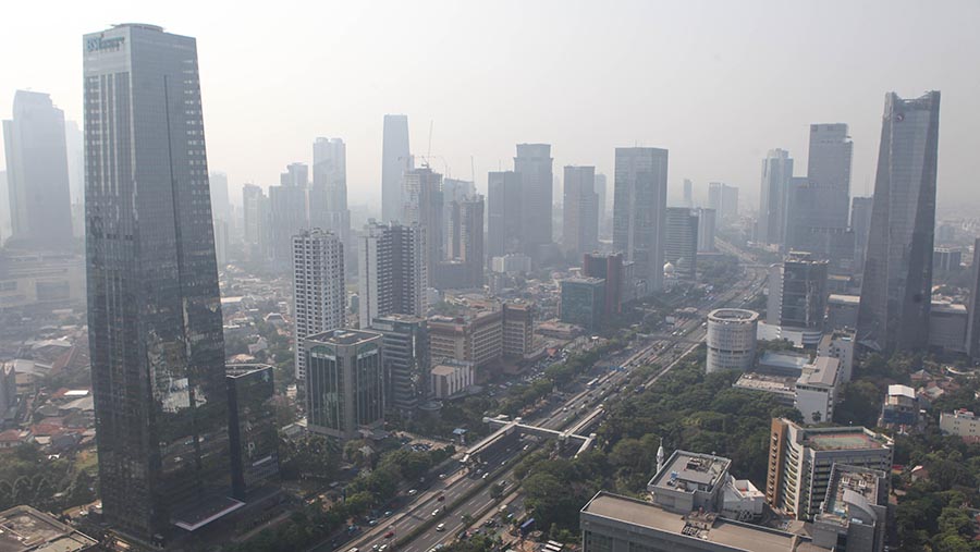 Suasana gedung bertingkat yang diselimuti polusi di kawasan Jakarta, Selasa (22/8/2023). (Bloomberg Technoz/ Andrean Kristianto)