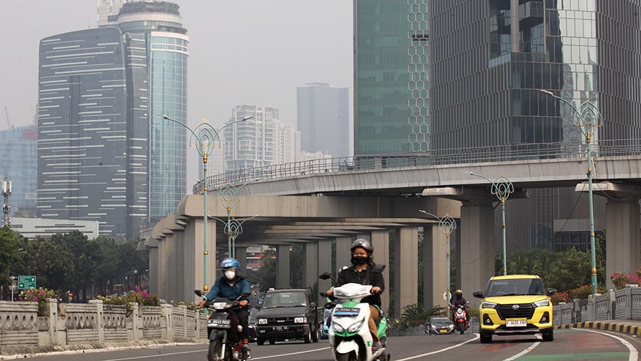 Suasana lalu lintas dengan latar gedung diselimuti polusi di Jakarta, Rabu (23/8/2023). (Bloomberg Technoz/ Andrean Kristianto)
