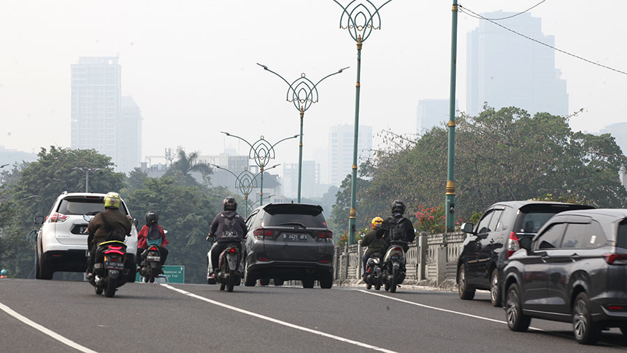 Suasana lalu lintas dengan latar gedung diselimuti polusi di Jakarta, Rabu (23/8/2023). (Bloomberg Technoz/ Andrean Kristianto)