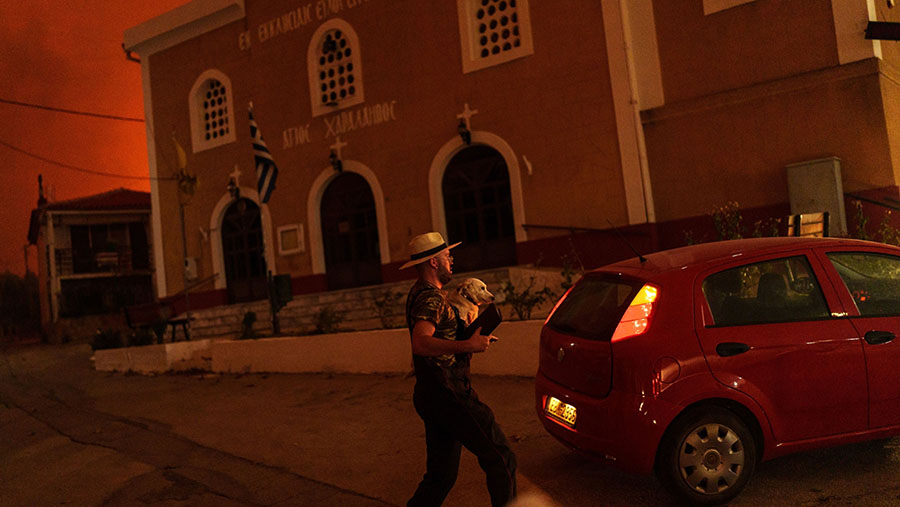 Hal ini disebabkan suhu yang melonjak tinggi, dan angin kencang menghambat upaya untuk mengendalikan kobaran api. (Konstantinos Tsakalidis/Bloomberg)