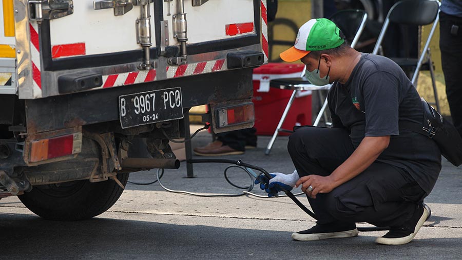 Petugas melakukan uji emisi kendaraan di kawasan Blok M, Jakarta Selatan, Jumatv (25/8/2023). (Bloomberg Technoz/ Andrean Kristianto)
