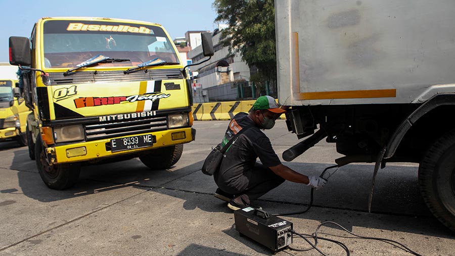 Petugas melakukan uji emisi kendaraan di kawasan Blok M, Jakarta Selatan, Jumat (25/8/2023). (Bloomberg Technoz/ Andrean Kristianto)