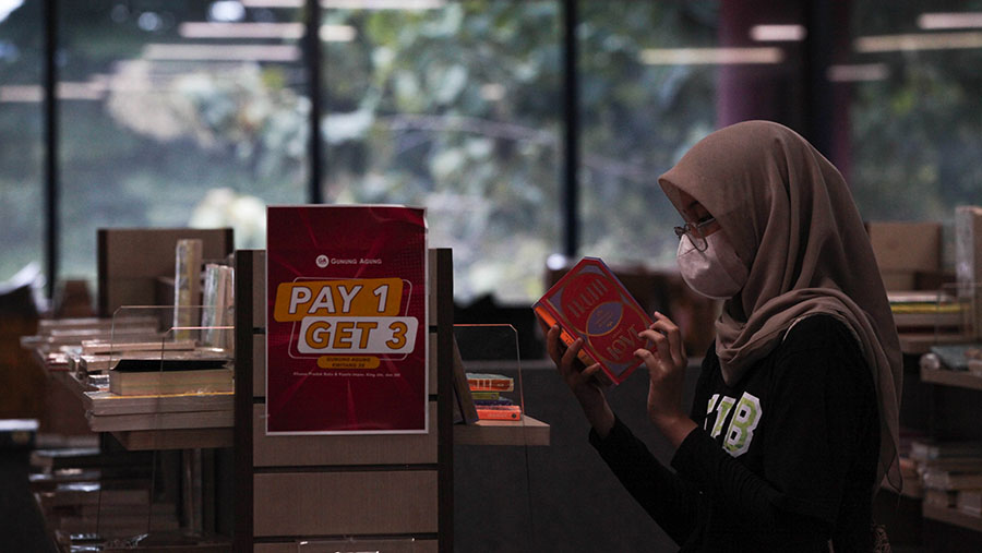 Pengunjung membaca buku di Toko Buku Gunung Agung, Kwitang, Jakarta, Selasa (29/8/2023). (Bloomberg Technoz/ Andrean Kristianto)