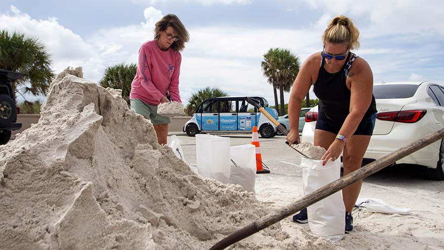 Warga mengisi karung pasir untuk mencegah banjir di St.Petersburg, Florida, AS, Senin (28/8/2023). (Juan Manuel Barrero Bueno/Bloomberg)