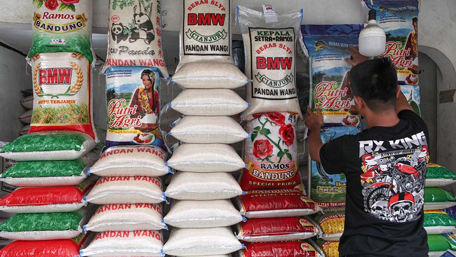 Pedagang merapihkan tumpukan karung beras di Jakarta, Selasa (29/8/2023). (Bloomberg Technoz/ Andrean Kristianto)