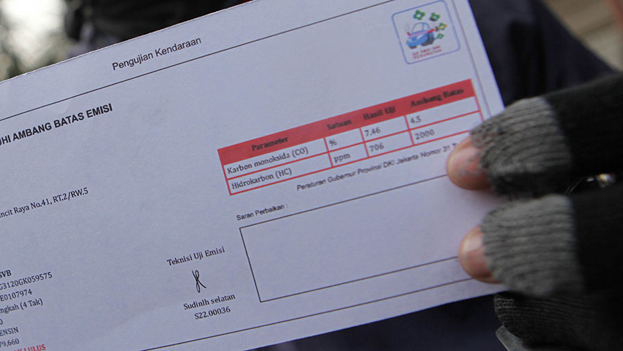 Warga memperlihatkan hasil uji emisi yang tidak lolos di kawasan Terminal Blok M, Jakarta, Jumat (1/9/2023). (Bloomberg Technoz/ Andrean Kristianto)