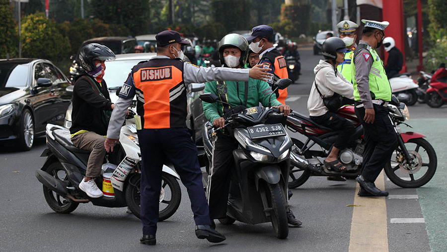 Poetugas memberhentikan kendaraan saat penerapan tilang uji emisi di kawasan Blok M, Jakarta, Jumat (1/9/2023). (Bloomberg Technoz/Andrean Kristianto)