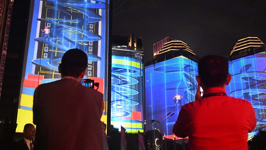 Di luar area Hutan Kota Plataran terlihat gedung bertingkat memperlihatkan pertunjukan video mapping. (Media Center KTT ASEAN 2023/Dhoni Setiawa)