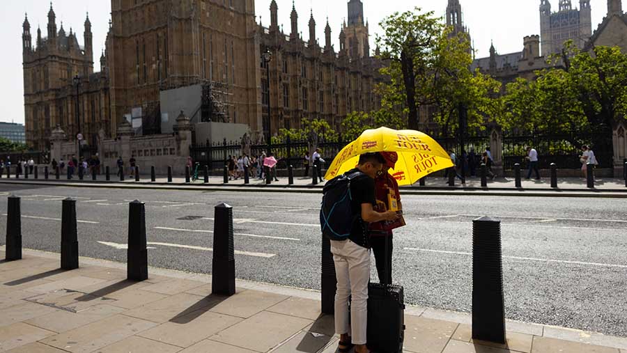 Seorang turis berbicara dengan pemandu wisata saat cuaca panas di London, Inggris, Rabu (6/9/2023). (Chris Ratcliffe/Bloomberg)