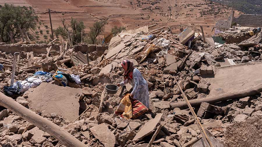 Warga berada di puing-puing bangunan yang hancur akibat gempa bumi di dekat Amizmiz, Al Haouz, Maroko, Minggu (10/9/2023). (Nathan Laine/Bloomberg)