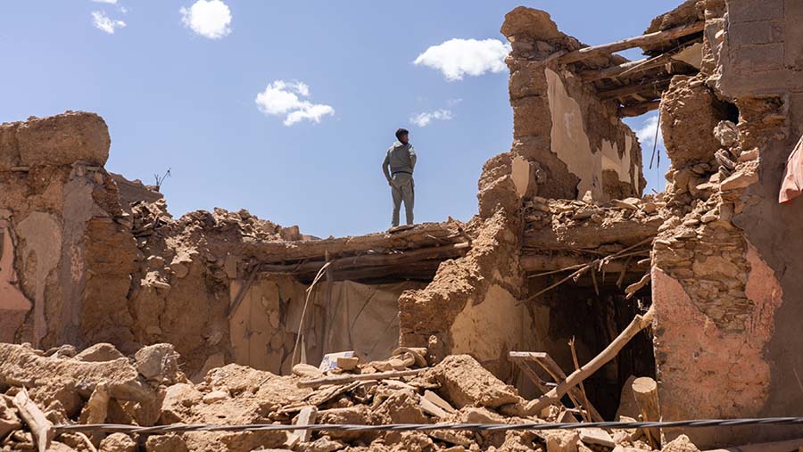 Warga berada di puing-puing bangunan yang hancur akibat gempa bumi di dekat Amizmiz, Al Haouz, Maroko, Minggu (10/9/2023). (Nathan Laine/Bloomberg)
