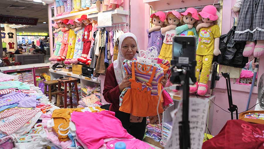 Pedagang berjualan melalui aplikasi live shopping di Pasar Tanah Abang, Jakarta, Selasa (12/9/2023). (Bloomberg Technoz/ Andrean Kristianto)