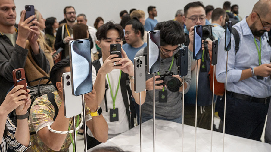 Pengunjung melihat Apple iPhone 15 pro di kampus Apple Park di Cupertino, California, AS, Selasa (12/9/2023). (David Paul Morris/Bloomberg)