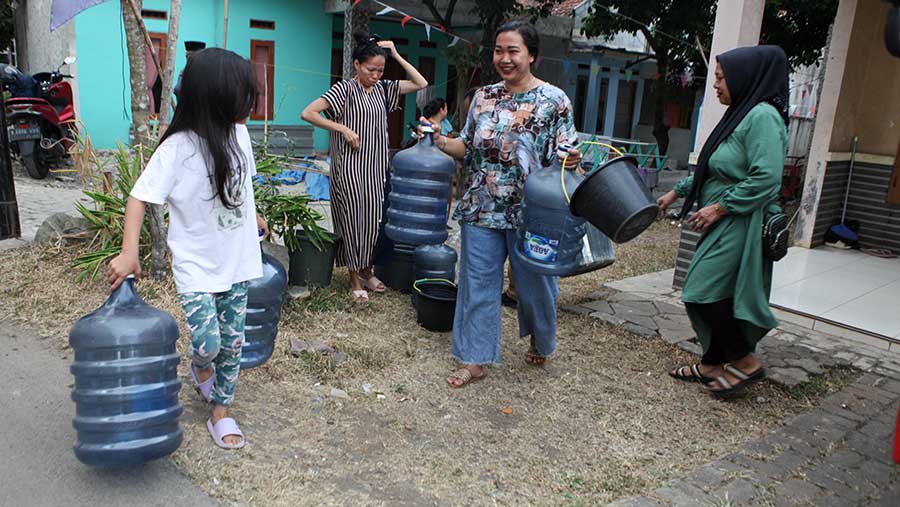 Warga membawa galon untuk diisi air di Sengkol, Muncul, Tangerang Selatan, Selasa (19/9/2023). (Bloomberg Technoz/Andrean Kristianto)