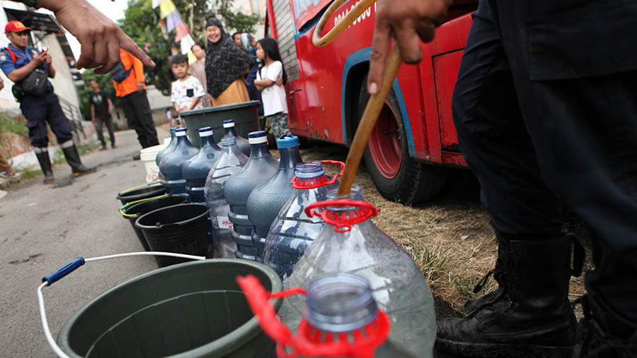 Warga mengisi air saat penyaluran bantuan air bersih di Sengkol, Muncul, Tangerang Selatan, Selasa (19/9/2023). (Bloomberg Technoz/Andrean Kristianto)