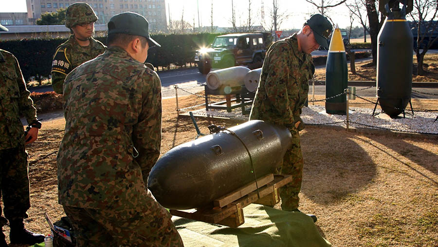 Petugas penjinak bom Jepang membawa persenjataan inert untuk membersihkan sisa Perang Dunia II di Jepang. (Koichi Kamoshida/Bloomberg)