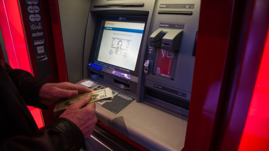 Ilustrasi mengambil uang dari mesin ATM. (Sumber: Bloomberg)
