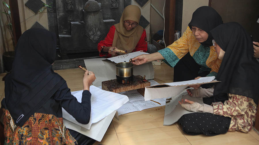 Siti Laela mengajarkan siswa SD membuat batik betawi di Batik Betawi Terogong, Jakarta, Senin (02/10/2023). (Bloomberg Technoz/Andrean Kristianto)