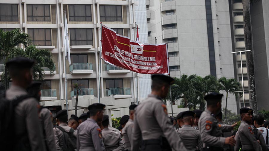 Pemasangan spanduk didampingi oleh sejumlah pihak kepolisian untuk melakukan pengamanan. (Bloomberg Technoz/Andrean Kristianto)