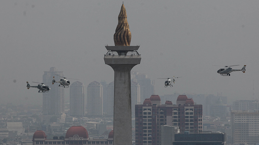 Helikopter TNI terbang saat peringatan HUT ke-78 TNI di Monas, Gambir, Jakarta, Kamis (5/10/2023). (Bloomberg Technoz/Andrean Kristianto)
