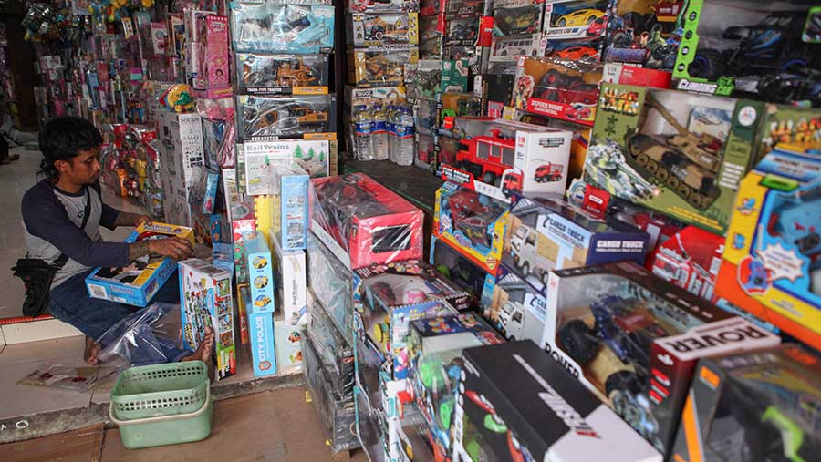 Pedagang merapihkan mainan anak yang dijual di Pasar Gembrong, Jakarta, Senin (9/10/2023). (Bloomberg Technoz/Andrean Kristianto)