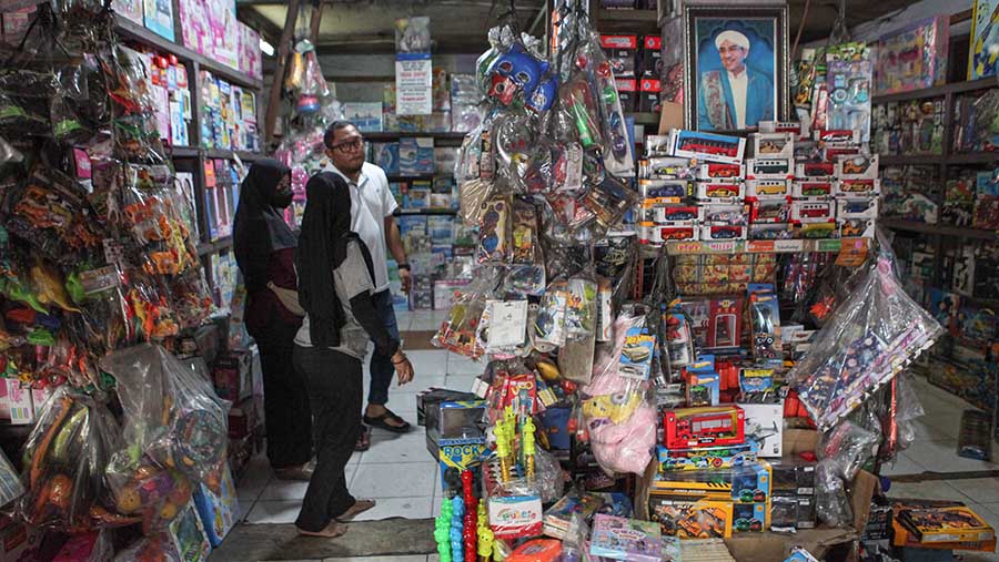 Pedagang melayani calon pembeli mainan anak yang dijual di Pasar Gembrong, Jakarta, Senin (9/10/2023). (Bloomberg Technoz/Andrean Kristianto)
