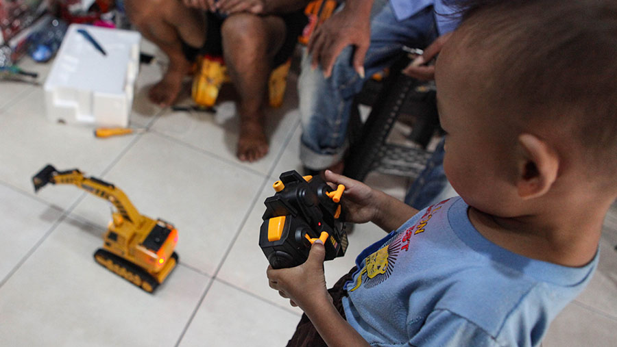 Seorang anak memainkan mainan yang baru dibelinya di Pasar Gembrong, Jakarta, Senin (9/10/2023). (Bloomberg Technoz/Andrean Kristianto)
