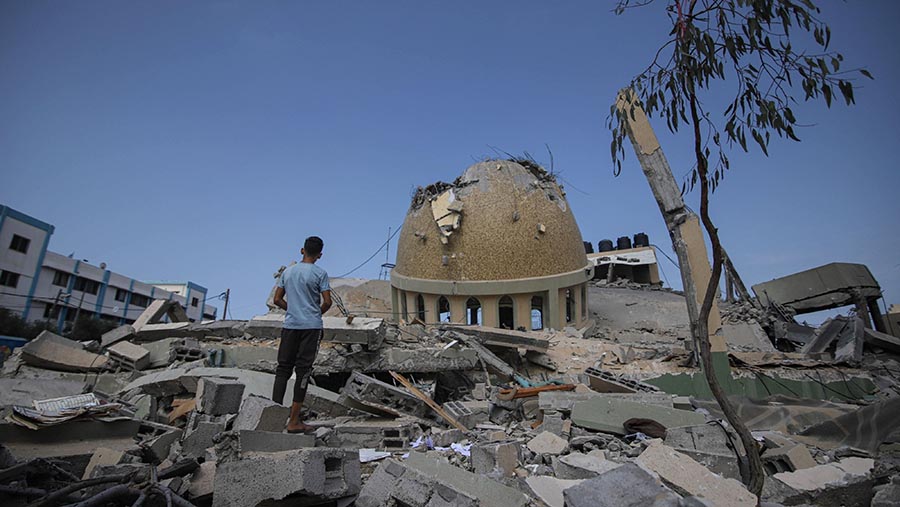 Seorang anak di lokasi masjid yang hancur usai serangan udara Israel di Khan Younis, Jalur Gaza, Minggu (8/10/2023). (Ahmad Salem/Bloomberg)