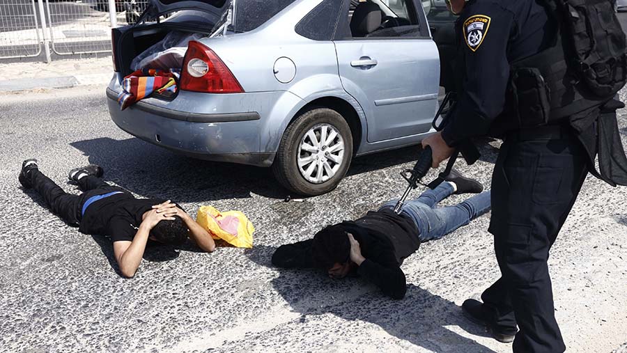 Polisi Israel memeriksa penumpang kendaraan di dekat Ashkelon, Israel, pada Minggu (8/10/2023). (Kobi Wolf/Bloomberg)