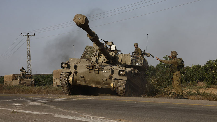Senjata self-propelled tentara Israel bergerak menuju perbatasan dengan Gaza di luar Sderot, Israel, Minggu (8/10/2023). (Kobi Wolf/Bloomberg)