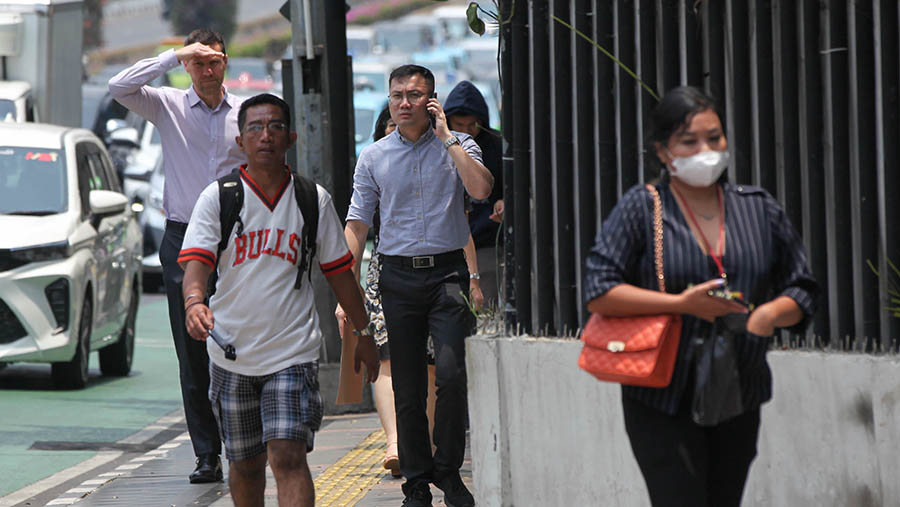 Warga berjalan saat cuaca panas di Jakarta, Selasa (10/10/2023). (Bloomberg Technoz/Andrean Kristianto)