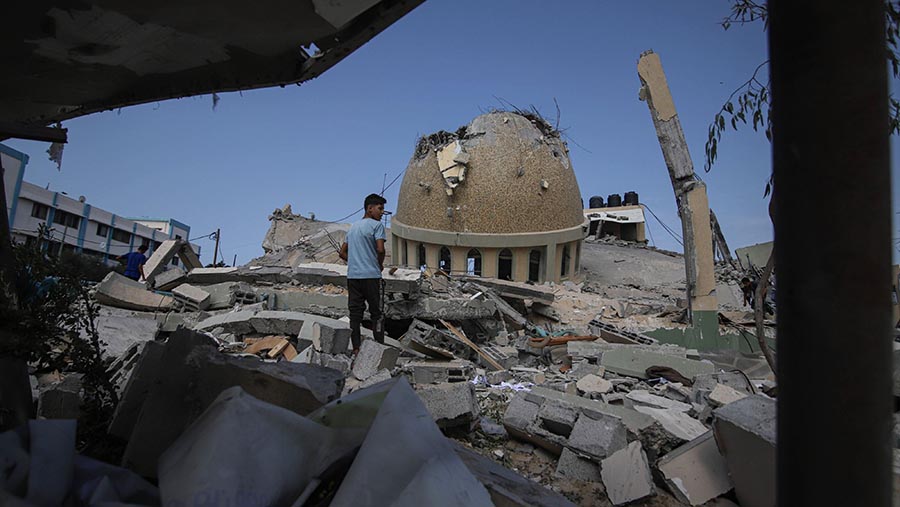 Warga berada di lokasi masjid yang hancur usai serangan udara Israel di Khan Younis, Jalur Gaza, Minggu (8/10/2023). (Ahmad Salem/Bloomberg)