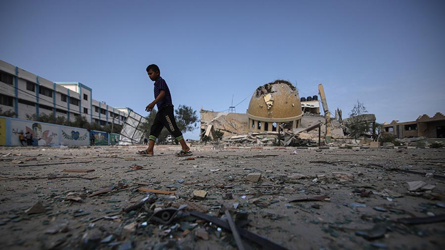 Warga berada di lokasi masjid yang hancur usai serangan udara Israel di Khan Younis, Jalur Gaza, Minggu (8/10/2023). (Ahmad Salem/Bloomberg)