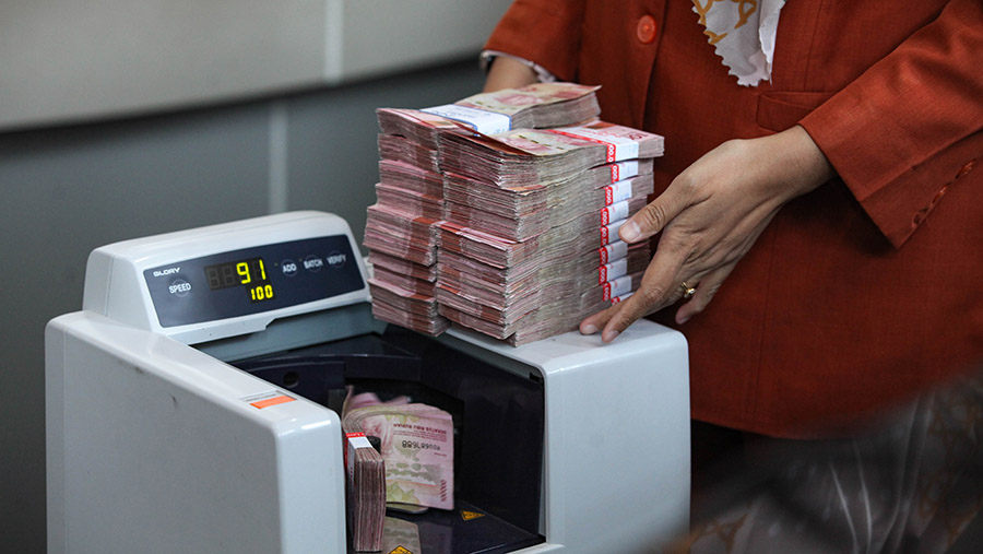 Karyawan menghitung uang rupiah di salah satu pusat penukaran uang di Jakarta, Rabu (11/10/2023). (Bloomberg Technoz/Andrean Kristianto)