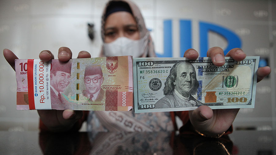 Karyawan memperlihatkan uang dolar AS dan rupiah di pusat penukaran uang di Jakarta, Rabu (11/10/2023). (Bloomberg Technoz/Andrean Kristianto)