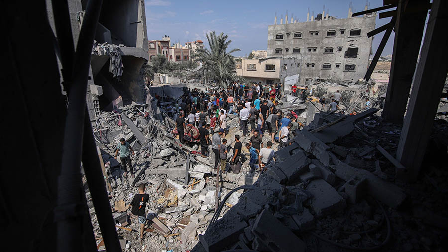 Warga mencari puing bangunan yang hancur usai serangan udara Israel di lingkungan Al-Amal, Jalur Gaza, Rabu (11/10/2023). (Ahmad Salem/Bloomberg)