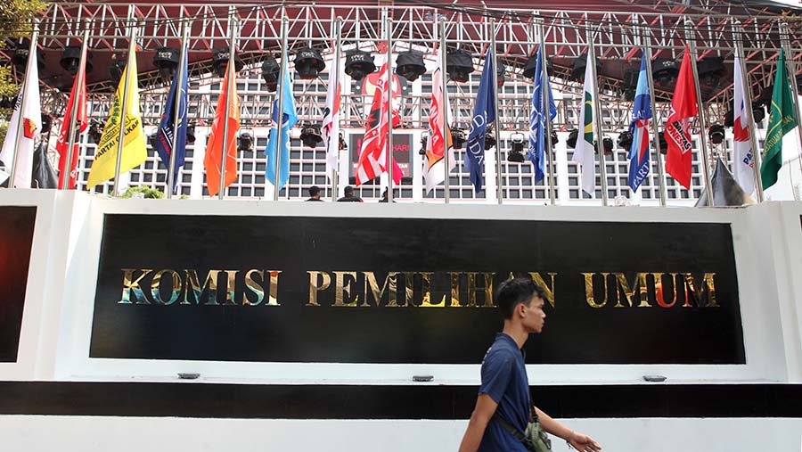 Warga berjalan di depan gedung KPU, Jakarta, Rabu (18/10/2023). (Bloomberg Technoz/Andrean Kristianto)