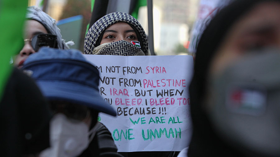 Sejumlah poster dukungan terhadap Palestina dan kecaman untuk Israel dibawa oleh peserta aksi. (Bloomberg Technoz/Andrean Kristianto)