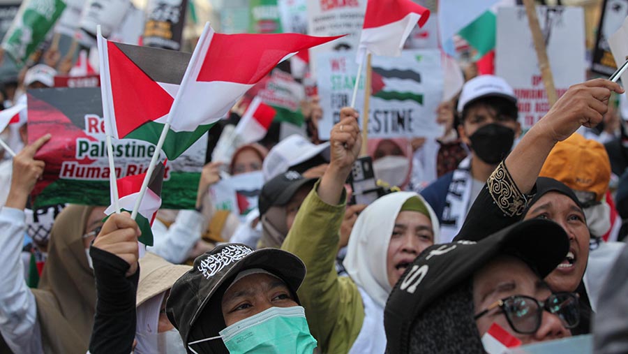 Bendera Palestina dan Indonesia menjadi atribut dalam aksi mereka. (Bloomberg Technoz/Andrean Kristianto)