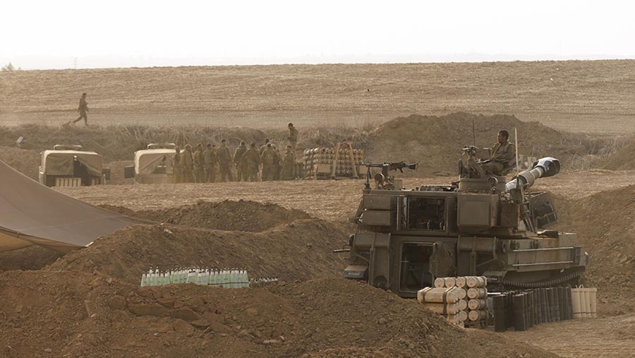Howitzer milik Israel bergerak di dekat perbatasan Jalur Gaza di luar Kibbutz Be'eri di Israel selatan, Minggu (22/10/2023). (Kobi Wolf/Bloomberg)